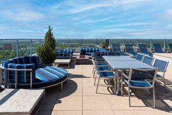 A patio with blue and white striped chairs and tables.